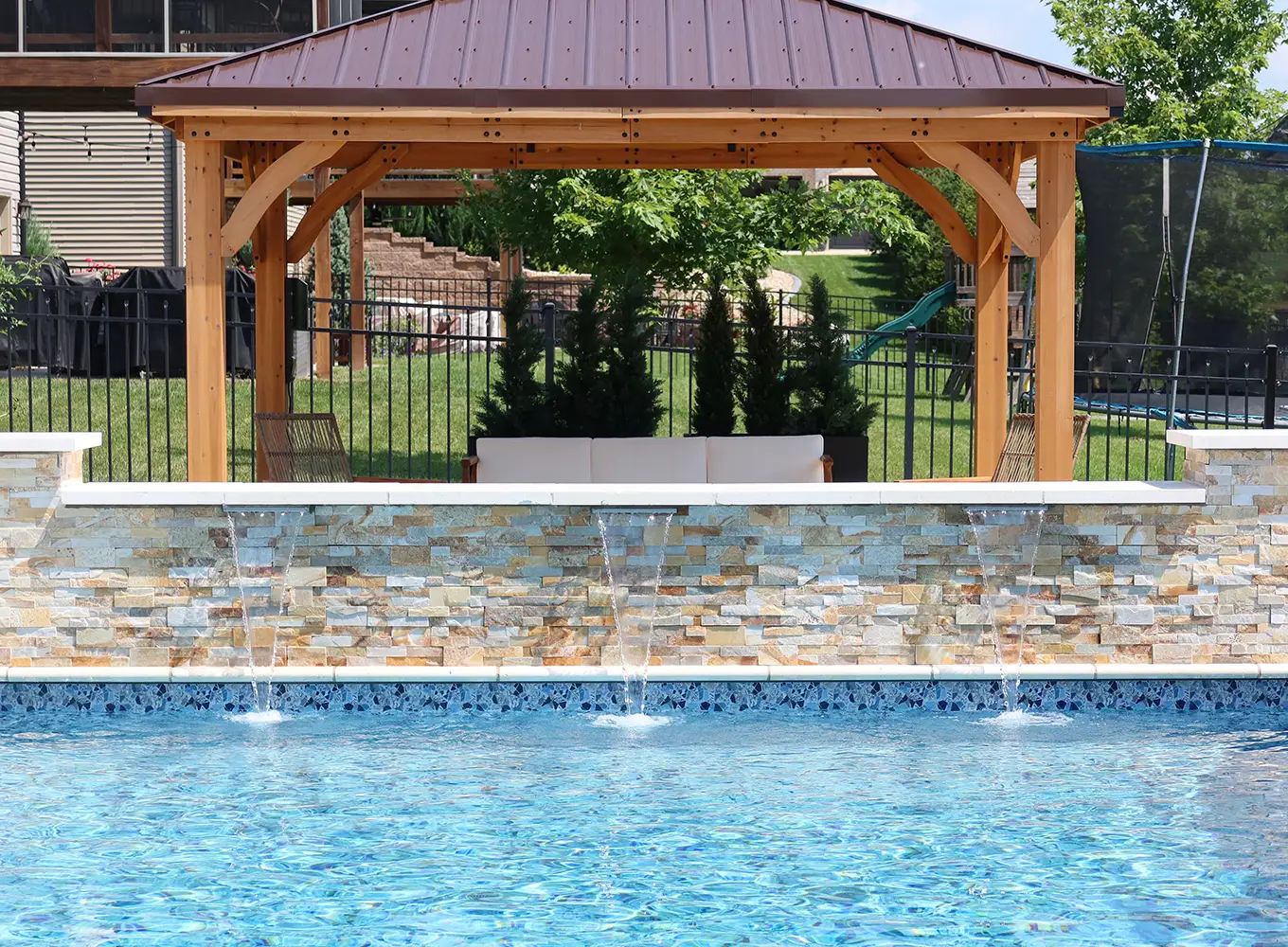 pavilion overseeing a pool with a custom build water feature in Collinsville IL